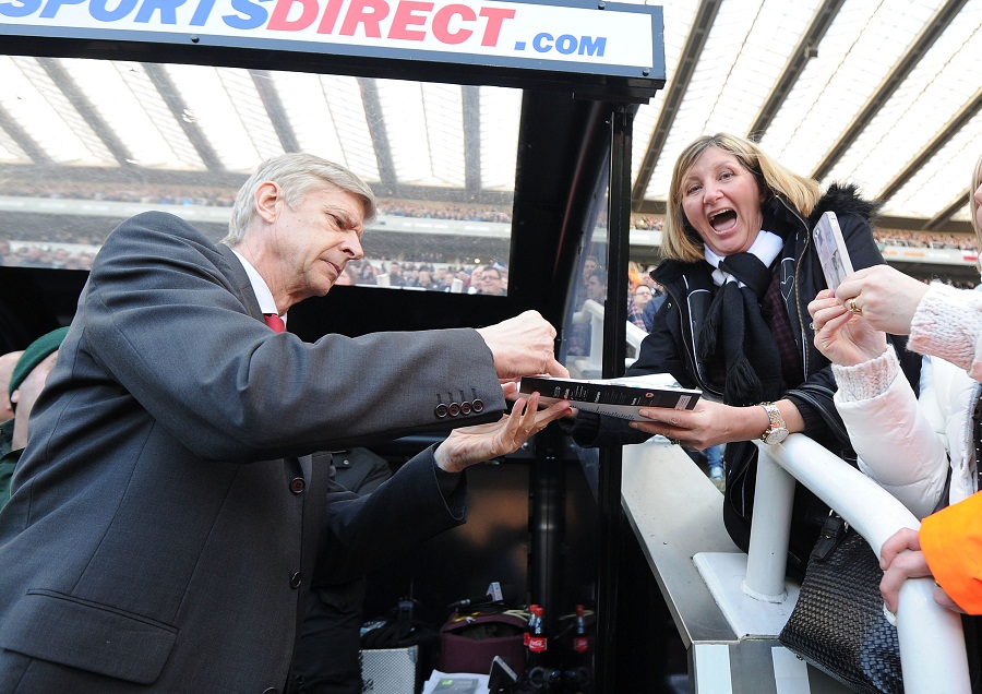 Arsene Wenger signs an autograph for a Newcastle fan