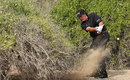 Phil Mickelson plays a shot out of a bush right-handed, resulting in a double-hit
