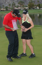 Patrick Reed pats the stomach of pregnant wife Justine as he holds the trophy