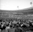 The crowd enjoy London's first open-air boxing match for many years during one of the preliminary matches held at Wembley Stadium before the heavyweight fight between American heavyweight Cassius Clay and British champion Henry Cooper