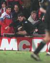 Eric Cantona jumps back onto the pitch after attacking a fan having been sent off