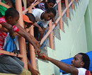 Chris Gayle meets some young fans in the stands during West Indies' training session in Guyana