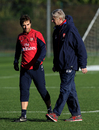 Arsene Wenger talks to Mathieu Flamini during an Arsenal training session