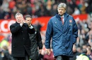 Sir Alex Ferguson applauds as Arsenal manager Arsene Wenger walks off dejected at Old Trafford