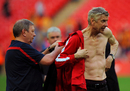 Arsene Wenger changes his shirt after being showered with beer
