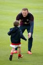 Wayne Rooney greets his son Kai at the end of a training session