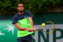 James Ward returns a shot in his second round French Open qualifier against Ryan Harrison