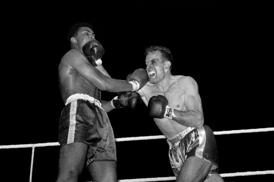 A bloody beaten Henry Cooper lands a shot on Cassius Clay