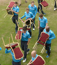 England players carry chairs across the field