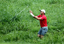 Jason Day is thrown a club to play out of thick rough in his bare feet at the US PGA Championship