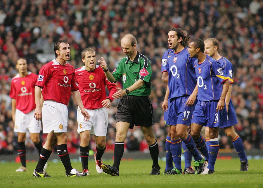Manchester United and Arsenal players surround referee Mike Riley