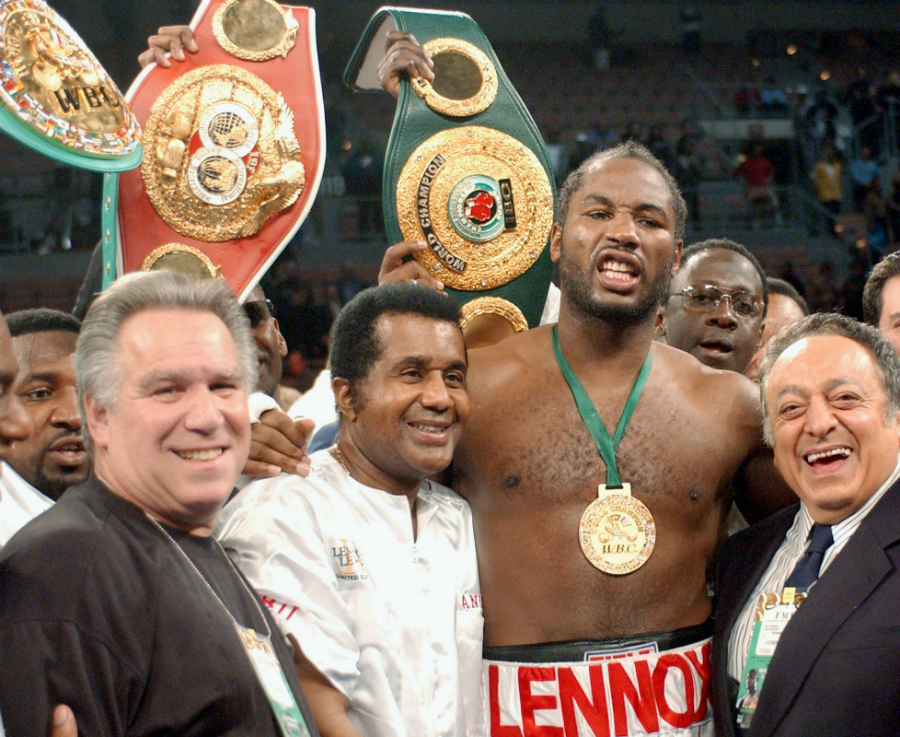 Lennox Lewis poses with his heavyweight belts after beating Hasim Rahman