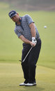 Graeme McDowell chips towards the hole in the first round of the WGC - HSBC Champions tournament