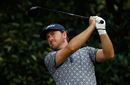 Graeme McDowell watches his tee shot on the fifth