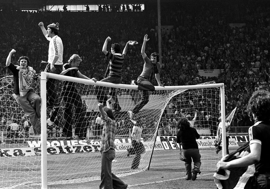 Scotland soccer fans on the crossbar of a goal at Wembley