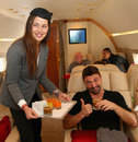 Ana Ivanovic takes on the roll of stewardess as she serves drinks to Goran Ivanisevic