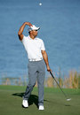 Tiger Woods throws the ball as he walks across a green
