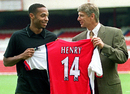 Thierry Henry holds up his new Arsenal shirt with Arsene Wenger