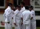 Steve Finn is congratulated by his England teammates on taking a couple of quick wickets after a lengthy rain delay