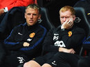 Coaches Phil Neville and Paul Scholes sit on the Manchester United bench