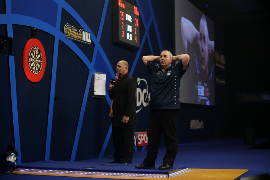Phil Taylor holds his head after missing three darts at double 12