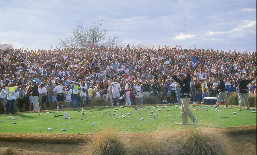 Fans throw beer onto the course in celebration as Tiger Woods makes a hole-in-one on the 16th