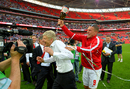 Arsene Wenger is drenched with champagne by Lukas Podolski