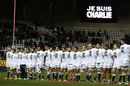 Stade Francais' players line up during a minute's silence