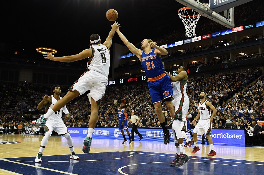 Jared Dudley of the Milwaukee Bucks challenges Lou Amundsen of the New York Knicks for the ball