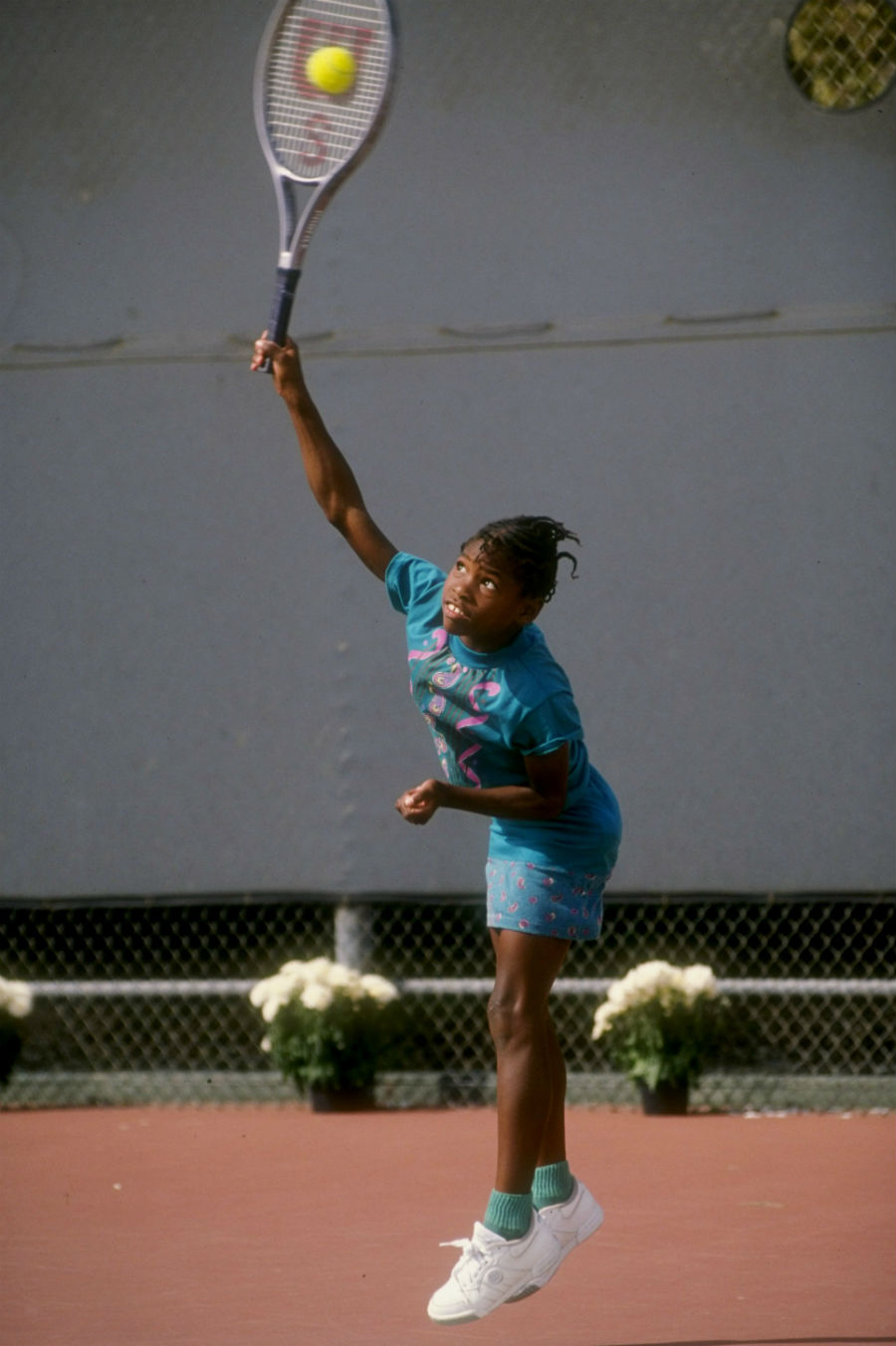 A young Serena Williams plays a shot