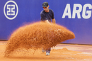 A worker adds dry clay to the court during a rain delay in the Argentina Open final between Rafael Nadal and Juan Monaco
