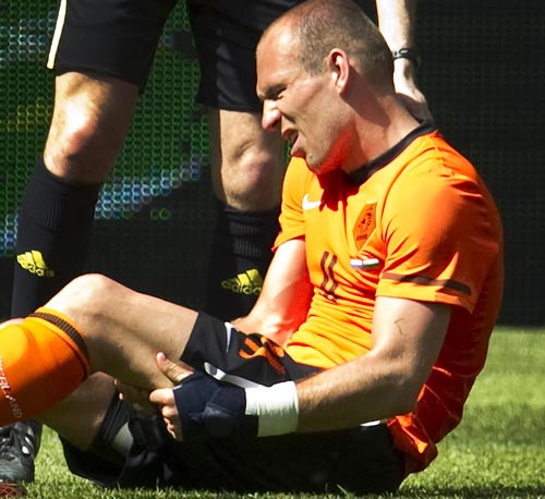 Arjen Robben holds his thigh after injuring himself