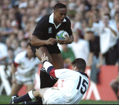 Jonah Lomu charges through the tackle of Mike Catt