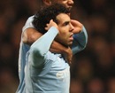 Carlos Tevez cups his ears to taunt Gary Neville