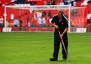 A groundsman works on the pitch